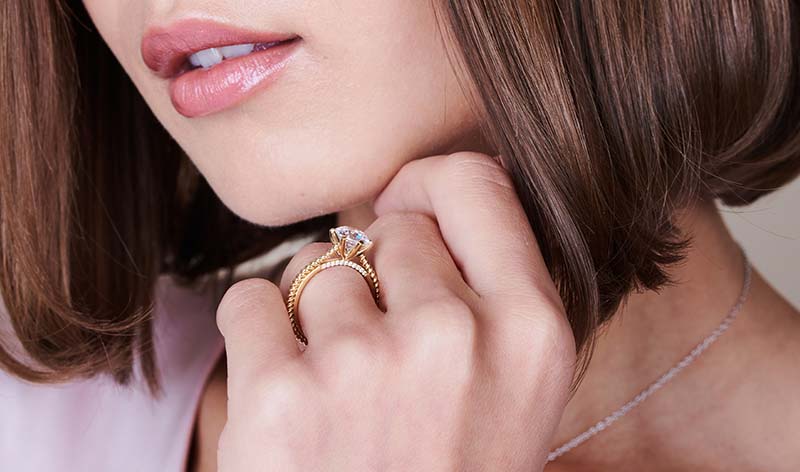 Woman wearing 14K yellow gold lab grown diamond engagement ring on hand