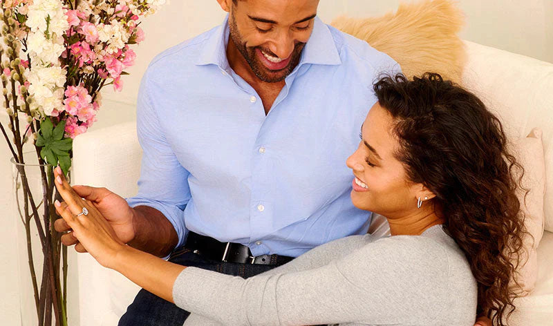 Husband gifting diamond engagement ring to wife from With Clarity