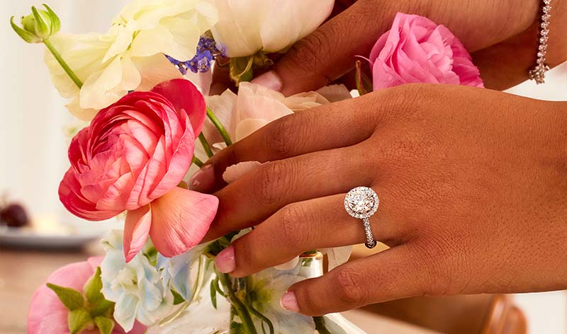 Woman wearing round cut lab grown diamond engagement rings on hand by With Clarity