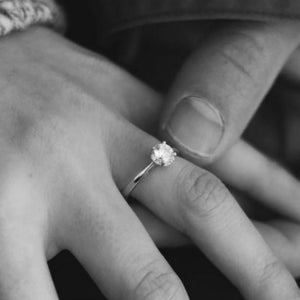 man holding hand of woman who's wearing a 1 carat diamond ring
