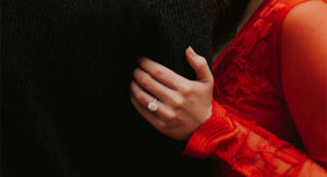 woman wearing engagement ring holding man's arm