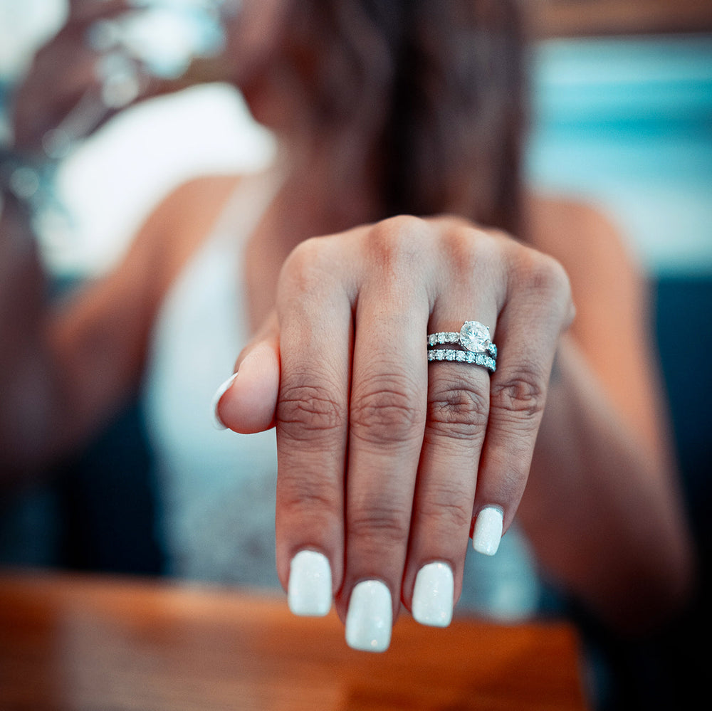 Woman wearing white gold engagement ring and wedding ring