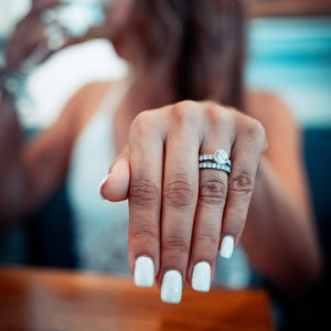 Woman wearing white gold engagement ring and wedding ring