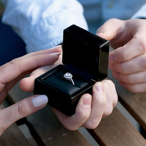 average diamond size in engagement ring man presenting woman with box