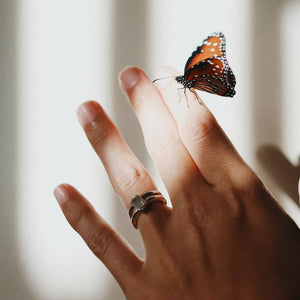 radiant cut engagement ring on woman's hand with butterfly