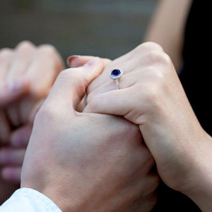 couple holding hands and woman wearing sapphire and diamond engagement ring