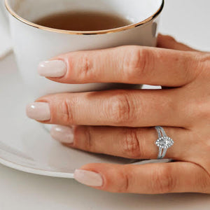 woman holding cup wearing marquise engagement ring