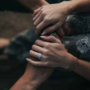 woman holding man's hand wearing big engagement ring