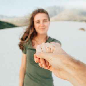 woman holding out hand wearing minimalist engagement ring
