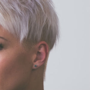 woman wearing emerald earrings