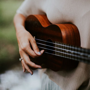 woman wearing low profile engagement ring and playing guitar