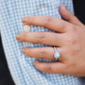 woman's hand wearing halo engagement ring