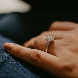 woman's hand wearing halo engagement ring