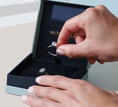 Man holding engagement ring with the box