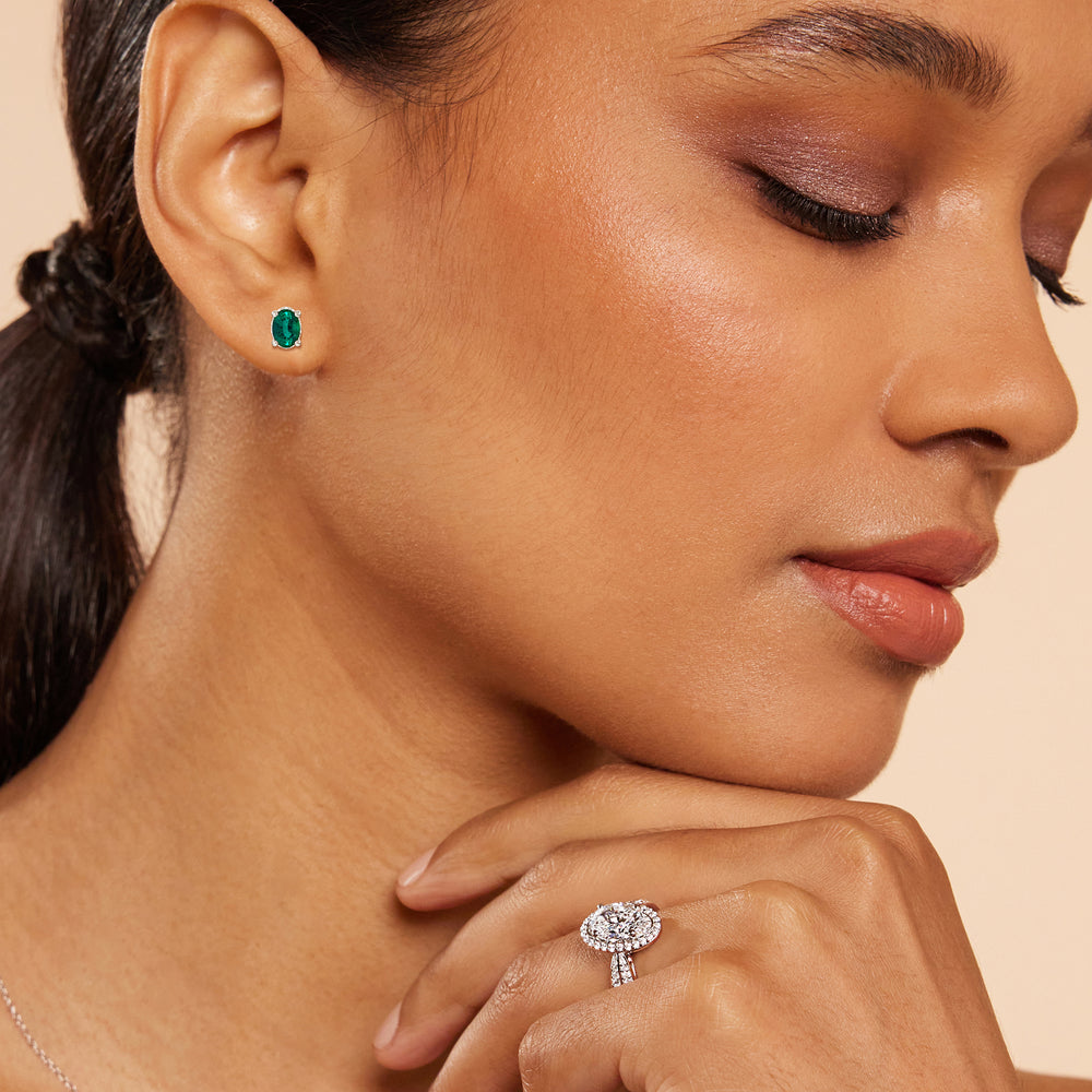 Model Wearing Oval Shape Emerald and Lab Diamond Classic Solitaire Under-Halo Earrings view