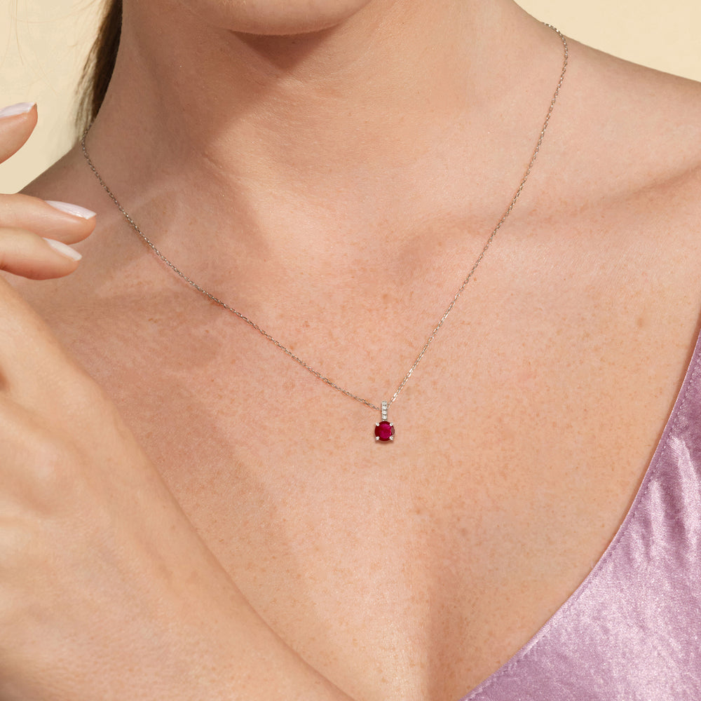 Model Wearing Round Ruby and Lab Diamond Classic Solitaire Pendant With Studded Bale view