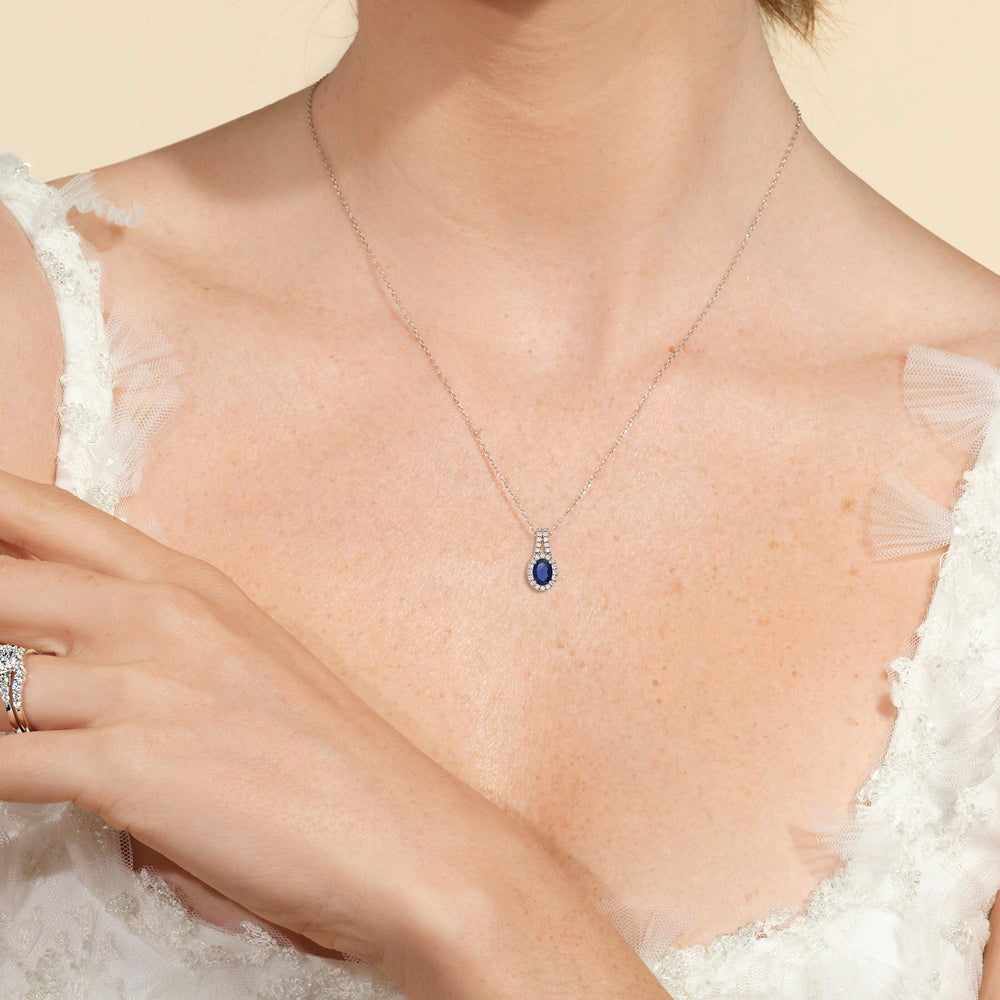 Model Wearing Oval Sapphire and Lab Diamond Classic Halo Pendant With Studded Split Bale view