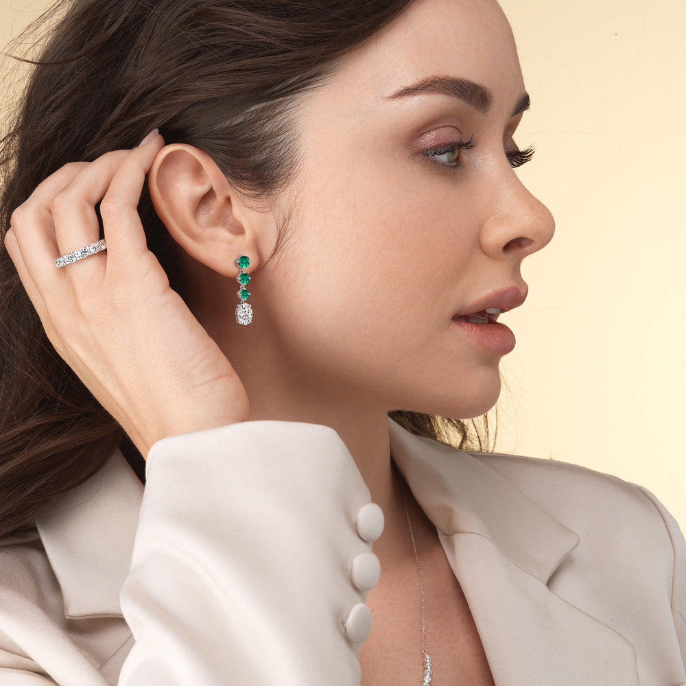Model Wearing Elegance Oval Diamond and Created Emerald Dangler Earrings view