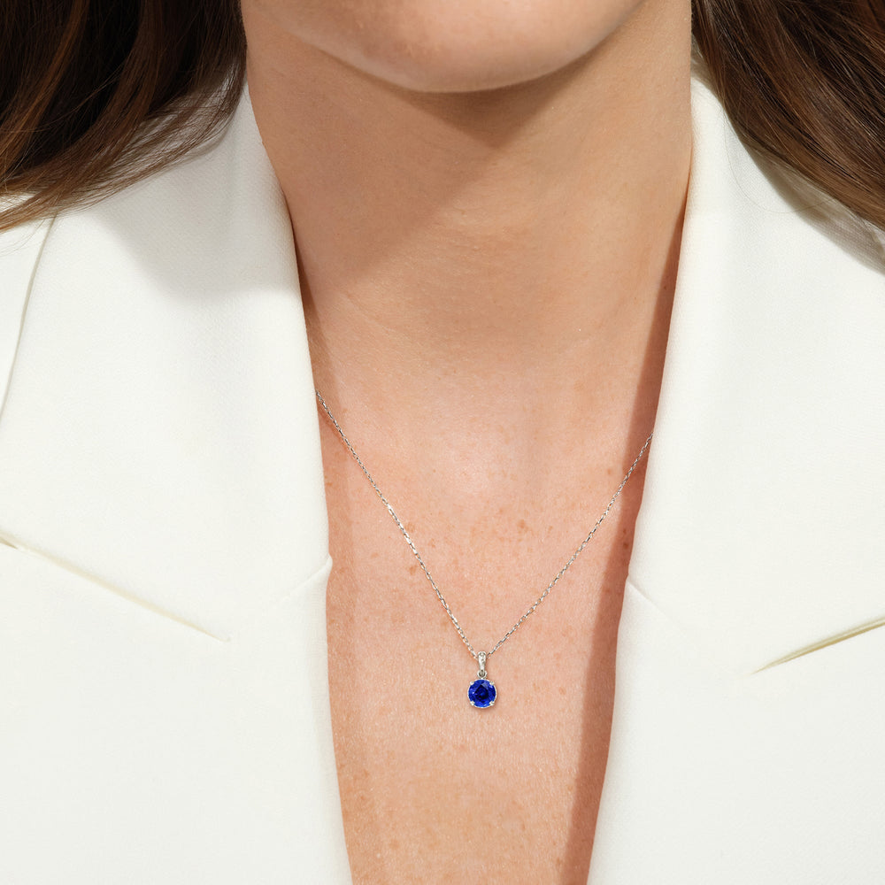 Model Wearing Round Created Sapphire and Lab Diamond Classic Solitaire Under Halo Pendant view